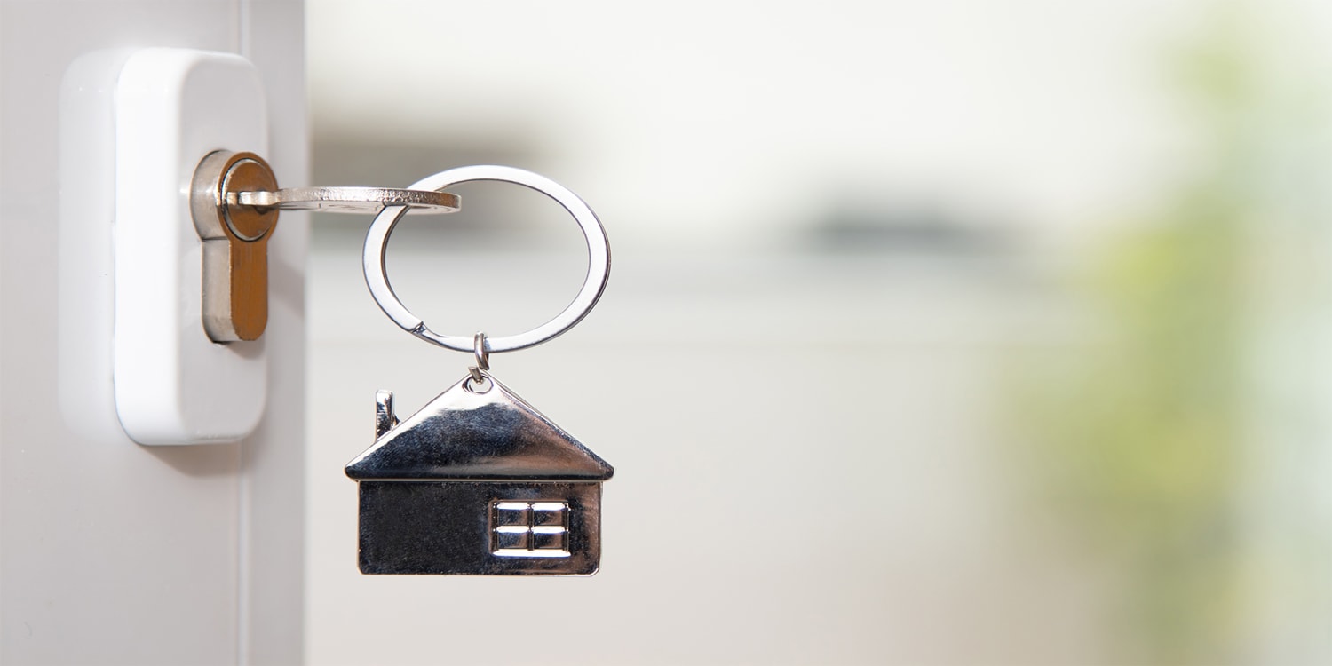 Key in door of rental property. Buy and hold investment concept.